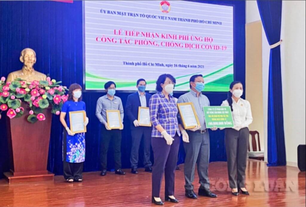 Ông Nguyễn Công Bình – Phó Tổng Giám đốc Hưng Lộc Phát trao bảng tượng trưng ủng hộ 100 triệu đồng kinh phí mua vaccine phòng ngừa Covid-19 cho bà Tô Thị Bích Châu, Ủy viên Ban Thường vụ Thành ủy, Chủ tịch Ủy ban Nhân dân Mặt trận Tổ quốc Việt Nam TP.HCM
